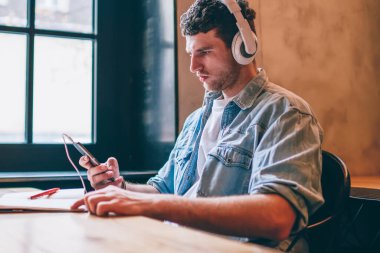 Elektronik kulaklıklı konsantre bir erkek melodisi sosyal ağlarda kendi müzikal blogunu arıyor, ciddi hipster adam müşteri hizmetleriyle mesajlaşıyor ödeme sorununu çözüyor.