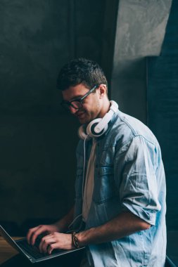 Mutlu pozitif hipster adam yeni dizüstü bilgisayarında yüksek kablosuz bağlantı kullanarak sosyal ağlarda iletişim kurdu. Başlangıç projesi için kampüsteki modern netbook üzerinden gülen adam araştırması yaptı.