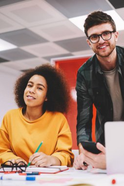 Neşeli hipster öğrenciler ise teamworking modern dizüstü bilgisayar, kamera gülümseyen portresi bağlı 4 g için Internet office Studio. Başarılı tasarımcılar ortak proje üzerinde işbirliği yapma