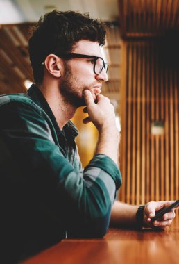 Genç profesyonel bu geliştirici başlangıç için yaratıcı fikirler hakkında durulması vizyon düzeltme için gözlük takıyor. Dizüstü bilgisayarda uygulama yüklerken program planlama sakallı hippi adam