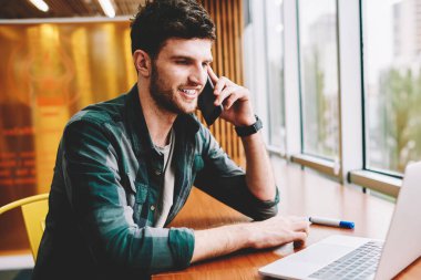 İyi neşeli bakarak akıllı bu programcı için 4 g bağlı hücresel kullanarak arkadaşlarınızla iletişim internet. Dizüstü bilgisayarda uygulama yükleme sırasında telefonla konuşurken başarılı hipster adam