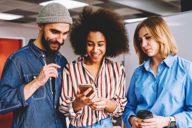 Çeşitlilik grubu başarılı grafik tasarımcıları Web sitesinde smartphone içinde komik video izlerken rahat kıyafet giymiş. Modern teknoloji kapalı ile zaman zevk olumlu erkek ve kadın arkadaş