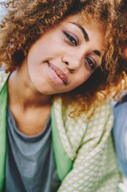 Genç mutlu evliliğin yakın bir portresi. Esmer tenli, kameraya gülümseyen pozitif bir çift. Neşeli Afro-Amerikan hipster arkadaşları, eğlenme zamanının keyfini çıkarıyorlar.