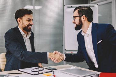 Formal giyim finans şirketi müreffeh ortaklığı ofiste toplantı sırasında el hareketi el sıkışan iki başarılı işadamları giymiş. Mutlu profesyonel tüccarlar işbirliği anlaşma var