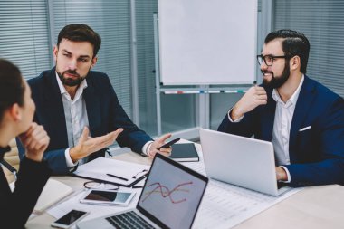 Ofiste toplantı masasında oturan profesyonel meslektaşları ile sabah brifing sırasında iş planı açıklayan kendine güvenen erkek gurur CEO'su. Strateji tartışmaya çalışanlarla işbirliği girişimci