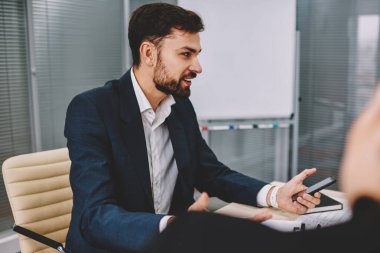 Yeni iş planı açıklayan ve tablo toplantıda brifing sırasında birlikte meslektaşları ile proje hakkında konuşmak formal giyim başarılı girişimci sakallı. Strateji tartışmaya müreffeh gurur ceo