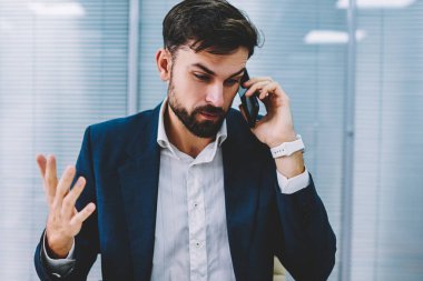 Öfkeli işadamı el eller ve smartphone için işlecini çağırmak çözme bankacılık sorunu. Telefon görüşmesi sırasında cep üzerinde çalışma sırasında office savunarak kızgın icra müdürü