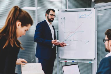 Flip grafik yanında duran ve dizüstü bilgisayar boş kopya alanı ekran reklam bilgin ile içerik tutan meslektaşları için açıklayan gözlük içinde icra müdürü deneyimli