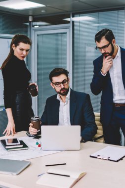 Yararlı bilgiler web sitesinde modern ofisinde oturum beyin fırtınası sırasında Internet'e bağlı dizüstü bilgisayar arama formal giyim grup yetenekli durulması hesap tüccarların giymiş