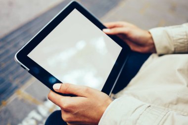 Boş ekran alanı için internet sitesi kadının elinde ile modern dokunmatik yüzey görünümünü kırpılmış. Hippi kız dijital tablet ile kopya alanı göstermek için açık havada oturma reklam holding