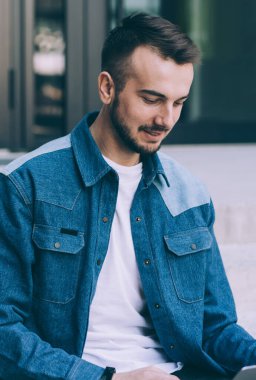 Gülümseyen beyaz adam blogcu modern teknoloji paylaşımı yayınını kullanıyor ve iletişim kuruyor, Webinar 'ı izleyen zeki genç hippi öğrenci dışarıda dizüstü bilgisayarla ders alıyor.