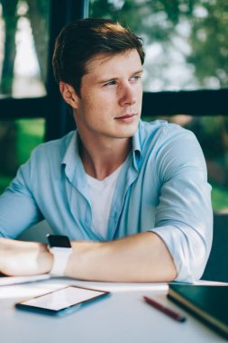 Genç adam serbest meslek uzak bilgi dizüstü bilgisayarda kablosuz internet kullanarak klavye süre seyir durulması. Düşünceli erkek hipster öğrenci ders çalışma için metin dijital netbook üzerinde yazma