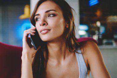 Uzakta yüksek hızlı mobil bağlantı kullanarak Smartphone'da çağrılırken arayan genç kadın büyüleyici durulması. İşleci ile digital kafede oturan hücresel konuşmak çekici hipster blogger