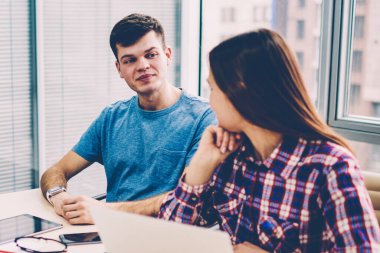 Genç kişilik ekibin tablo modern ofis dizüstü bilgisayarlar ile Toplantı oturan başlangıç projesi için yaratıcı fikirler tartışırken rahat kıyafet giymiş. Erkek ve kadın tasarımcılar yeni görev üzerinde işbirliği yapma