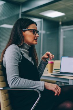 İki kadın arkadaşları konuşuyor ve tasarım projesi ile boş ekran alanı Internet içeriği veya Web sitesi için modern dizüstü bilgisayar ile masada oturan tartışırken rahat kıyafet giymiş