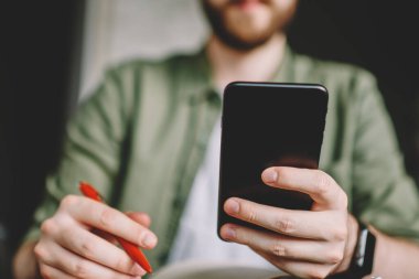 Seçici odak üzerinde modern siyah smartphone tutarak ve 4 g bağlantısını kullanarak internet sitelerinde bilgi arama erkek eli. Sohbet online dijital cep telefonu aygıtta öğrenci