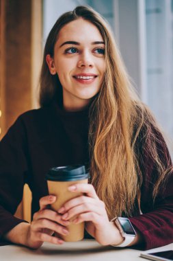 Kahve molası Üniversitesi sonra uzağa sevimli gülümseme ile yüz, Genç olumlu hipster kız casual giyinen dinlenme ve bekleyen arkadaş rahat kafeteryada bakarken zevk neşeli kız öğrenci