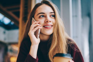 Mutlu gülümseyen hippi kız olumlu smartphone üzerinden arkadaşıyla sırasında sabah kahve Üniversitesi kafeterya, kapalı müşteri hizmetleri çağrı neşeli kadın Genç, muhabbet