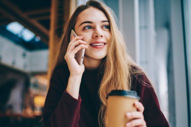 Mutlu gülümseyen hippi kız olumlu smartphone üzerinden arkadaşıyla sırasında sabah kahve Üniversitesi kafeterya, kapalı müşteri hizmetleri çağrı neşeli kadın Genç, muhabbet