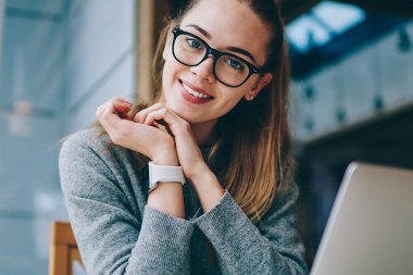 Teknoloji ve iletişim, modern netbook ile yer yüzünde gülümsemeyle kameraya bakarken coworking, vakit Eyewear mutlu müreffeh kadın serbest meslek portresi kavramı