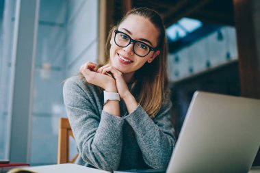 Teknoloji ve iletişim, modern netbook ile yer yüzünde gülümsemeyle kameraya bakarken coworking, vakit Eyewear mutlu müreffeh kadın serbest meslek portresi kavramı