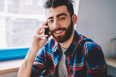 Mutlu erkek öğrenci kontrol denge ise istek-e doğru müşteri hizmet istimal cellphone kapalı, cep telefonu aracılığıyla iletişim ve kamera kahve dükkanında bakarak neşeli hipster adam portresi