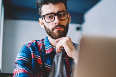 Gözlük kamera dizüstü bilgisayar, yakışıklı erkek üzerinde önemli web konuşma sonra geliştirici bakarak ciddi hipster adam portresi modern netbook ile çalışma kafeteryada rahat giyinmiş