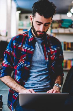 Araştırma için modern dizüstü kullanarak ve online ders Üniversitesi kampüsünde otururken okuyan genç erkek öğrenci konsantre yetenekli hipster adam bilgisayar üzerinden online sosyal ağlar sohbet