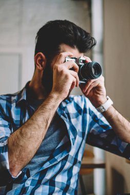 Yetenekli yaratıcı beyaz hipster adam genç profesyonel erkek fotoğraf görüntü retro eski moda teknolojisi ile kapalı alarak kafeterya penceresini vintage fotoğraf makinesi kullanarak resim yapma
