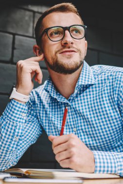 Gözlük uzakta kendi iş projesi geliştirmek için yaratıcı fikirler üzerinde düşünürken seyir vizyon düzeltme için düşünceli genç adam. Düşünceli zeki öğrenci için ders planları üzerinde durulması