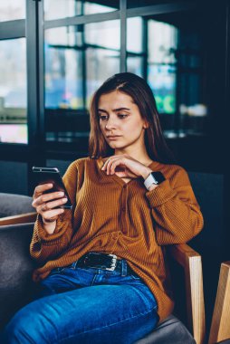 Konsantre kadın genç gülümseyen süre 4 g bağlantısıyla cep telefonu kullanarak hareket için uygulama ile ödeme yapma yakın oturan ve takipçileri cep telefonu ile mesajlaşma kadın arkadaş