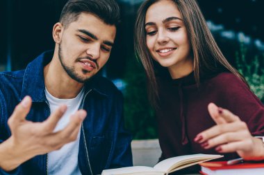 Komik hipster adam birlikte, çekici bir kadın öğrenci bilgilerini kafe terasında Not Defteri'nden kontrol arkadaşıyla danışmanlık projesi için fikirler tartışıyor kadın meslektaşı ile vakit