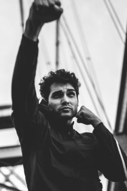 Konsantre suratla sabah eğitim sırasında güçlü iyi görünümlü adam gücü ile güç yumruk şehir Köprüsü üzerinde pratik Erkek atlet şampiyon boks ve mücadele kentsel ayarı için hazırlanıyor