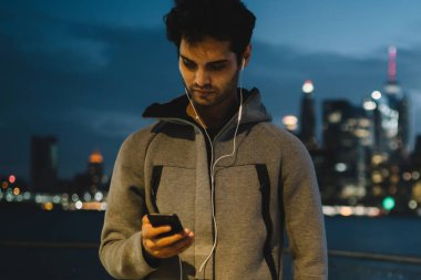 Kardiyo egzersizleri için kablosuz 4 g kullanarak kendi spor blog hakkında yayın oluşturma spor genç adam Internet üstünde hareket eden telefon, Erkek koşucu zevk egzersiz break ve cep telefonundan tebliğ