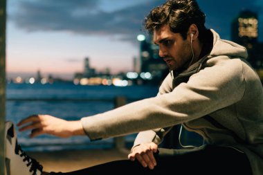 Erkek koşucu esneklik egzersizleri dinleme motivasyon sesli kitap yolu ile elektronik kulaklık, genç sporcu eğitim kas açık havada sırasında vücut dengesi ile yardım için egzersiz işlem ekleme