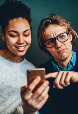 Akıllı telefondan ağ kurduğu için kötü kablosuz bağlantıdan rahatsız olan binlerce yıllık üzgün beyaz erkek portresi, çok ırklı arkadaşlar cep telefonuna uygulama yüklemede sorun yaşıyor