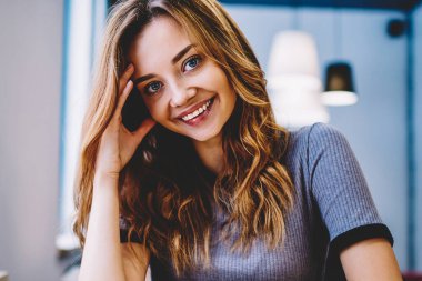 Masada oturan ve yüzünde, neşeli kız öğrencinin duygu iyi ve müreffeh Üniversitesi Kampüsü vakit sevimli gülümseme ile kameraya bakarak Genç olumlu hippi kız portresi