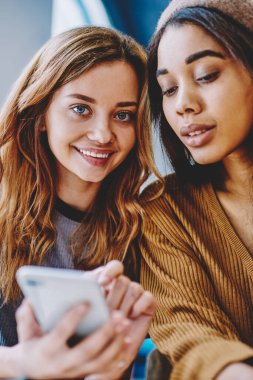 Smartphone aygıtı elinde tutan ve bilgi multimedya uygulama üzerinden cep arama olumlu gülümseyen kadın kadın arkadaş oturan mutlu başarılı hippi kız portresi