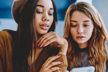 Ciddi bayan arkadaş, arkadaş smartphone aygıt üzerinde sohbet için uygulama kullanarak kısa mesaj okuma iki bin yıllık hipster kızlar cep telefonu üzerinden bilgi arama konsantre