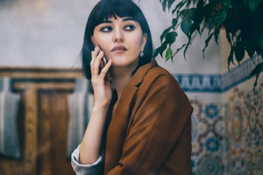 Ciddi yoğun hippi kız uzakta meslektaşı, dalgın kadın müşteri hizmetleri kafeterya, hücresel telefon yoluyla alınan bilgiler üzerinde durulması ile telefon görüşme sırasında seyir düşünceli