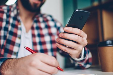 Mutlu erkek bildirim modern smartphone planlama gün elinde tutan indir yeni sürümü uygulama çalışırken telefon adama'nın seçici odak ders kitabı, kırpılmış görüntü yazma denetimi