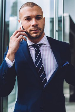 Kendine güvenen işadamı açılış kapı ve git smartphone aygıtında çağrılırken bina işyeri dışında portresi. Formal giyim cep telefonu iletişim genç girişimci giymiş