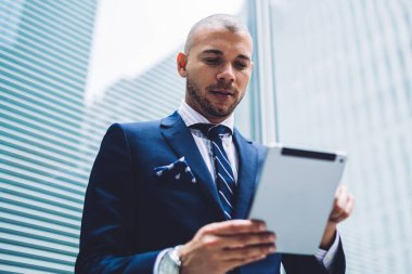4 g kullanarak internet sitelerinde finansal haber okuma görünümünün resmi başarılı erkek tüccar altındaki giymek internet üzerinde modern tablet ayakta iş şehrin modern gökdelenler ile sokakta