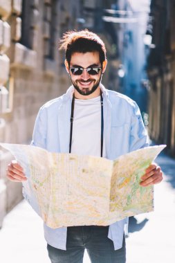 Mimari şehrin sokaklarında gezen neşeli sakallı erkek aşıklar haritada doğru yönü arıyorlar. Şık giyinmiş, güneş gözlüklü, şehir merkezinde gezinen turist.