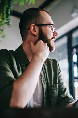 İyi hipster adam 20 yaşında yarın işten tatilinde yeni cep telefonu kullanarak planlama düşünceli bir kenara ile smartphone, restoranda otururken arıyorum Genç beyaz adam bakan