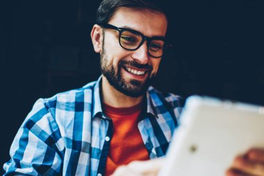 Dijital tablet izlerken öğretici bağlı 4 g için gözlük neşeli sakallı hippi adam Internet. Aygıt olumlu erkek blogger okuma komik yorum altında yayın modern Touch pad