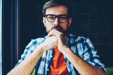 Kameraya bakarak sağlamak gözleri koruma için optik gözlük sakallı genç adam yarım uzunluk portre. Yakışıklı erkek blogger ciddi bir yüz ile şık casual gömlek giymiş