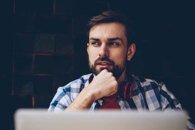 Düşünceli sakallı erkek o serbest modern dizüstü bilgisayar, kablosuz 4 g ile çalışma programı geliştirilmesi üzerinde düşünme profesyonel internet. Yayın için fikirler üzerinde durulması şaşkın genç adam