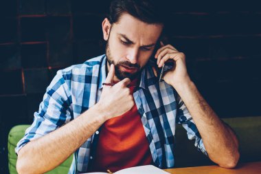 Dalgın sakallı hippi adam akıllı planı üzerinde düşünürken arama. Telefonla kafede oturan telefon görüşmesi sırasında istemci ve çözme sorunları ile konuşan genç adam konsantre
