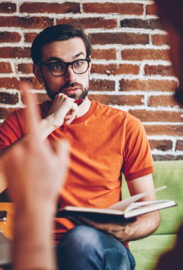 Masada oturan şık coworking alanda iş toplantısı sırasında meslektaşım gözlük gelişmekte olan başlangıç projesi ise dikkatle stratejisi ile şok heyecanlı sakallı genç adam dinleme